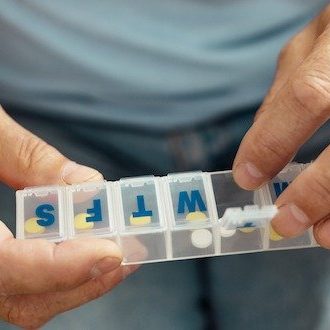 Nice aged man opening a pill container reverse diabetes - take medication