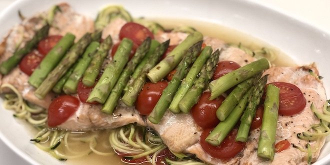 Salmon trout with spiralized zucchini, asparagus and tomato en papillote