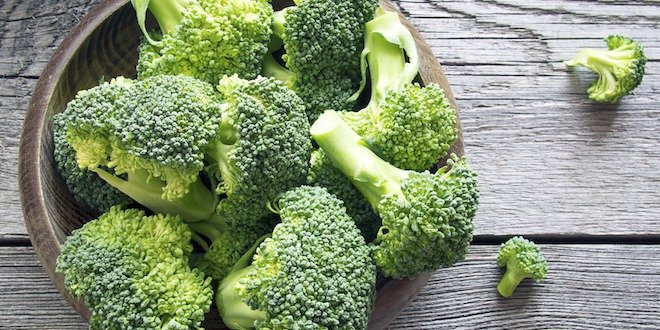 Raw broccoli on wooden background Raw broccoli in a bowl on rustic background