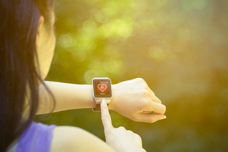 Female runner checking heart rate on smart watch outdoors Why exercise is good for diabetes