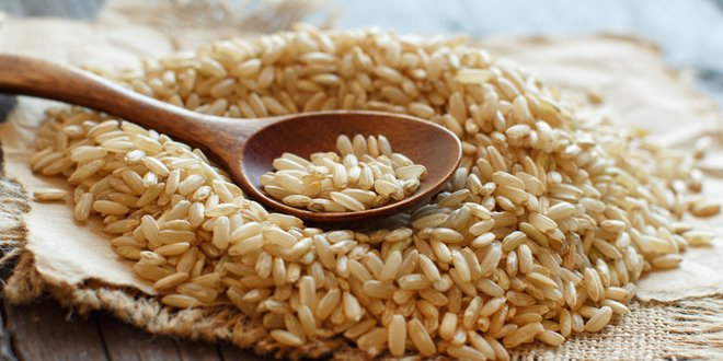 Pile of Brown rice with a wooden spoon rice