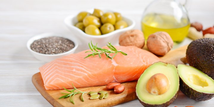Selection of healthy unsaturated fats, omega 3 - fish, avocado, olives, nuts and seeds.