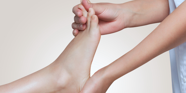 The doctor-podiatrist does an examination and massage of the patient's foot The doctor-podiatrist does an examination and massage of the patient's foot in the clinic.