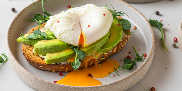 Sandwiches with avocado, poached egg, sprouts and cheese for healthy breakfast on white background. top view avocado and cholesterol