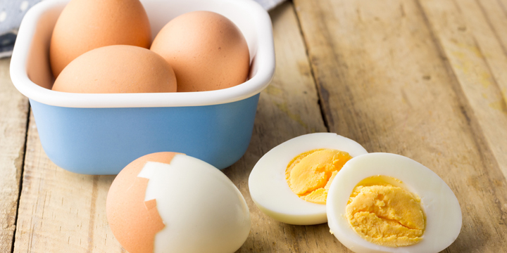Hard boiled chicken eggs on rustic wooden table