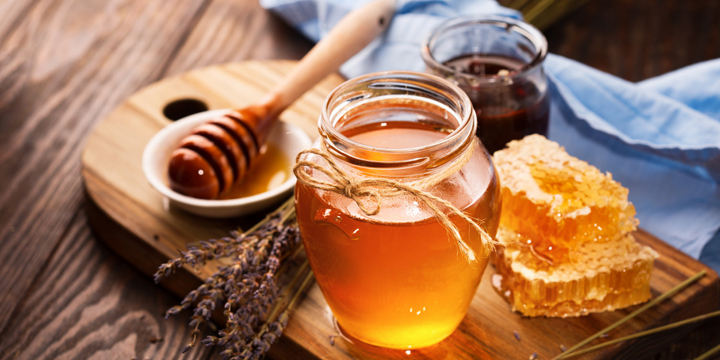 Honey in jar and bunch of dry lavender