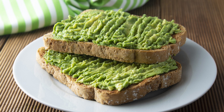 Healthy avocado sandwich, toast bread. Mushed avocado paste, on wooden background. Guacamole.