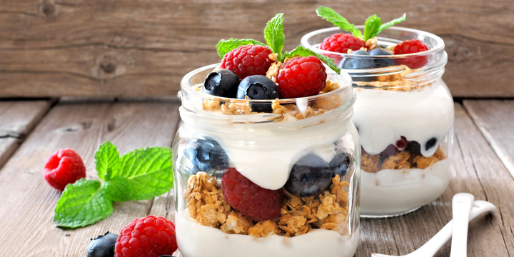 Blueberry, raspberry parfaits in mason jars, still life against wood