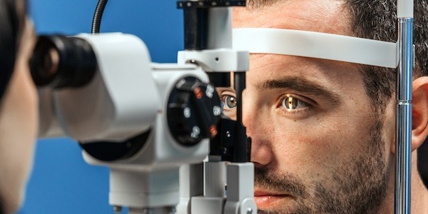 Male patient undergoing detailed vision examination using a slit lamp device, showcasing the intricate process of ophthalmic assessment and eye health evaluation