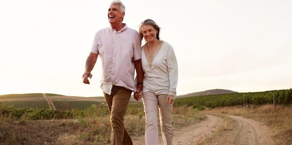 Countryside, walking and holding hands with senior couple, romance and relationship with vacation for honeymoon. People, space and outdoor with old man, mature woman and farm with marriage and love
