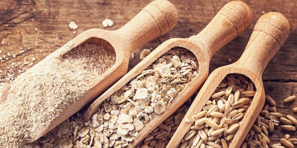 Oat flakes, seeds and bran in spoons