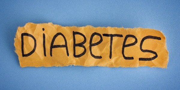 Torn piece of yellow paper with the word DIABETES. Close up.
